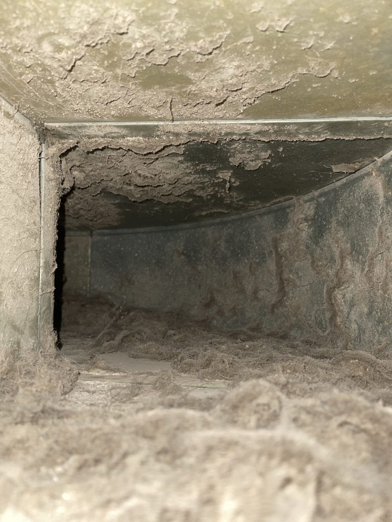 Close-up of a corroded, grime-covered duct corner